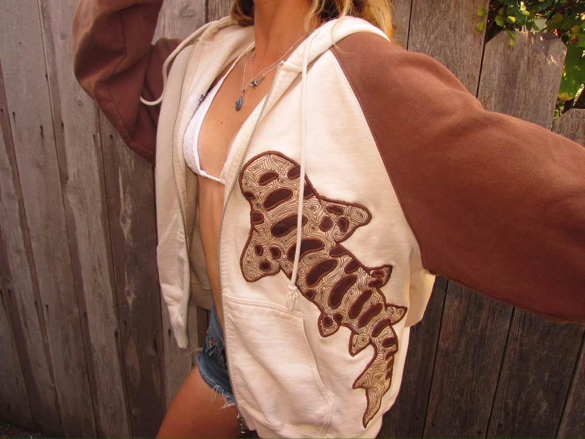 Cream and brown zip-up worn open, showing the leopard shark cloth pattern and stitched outline.